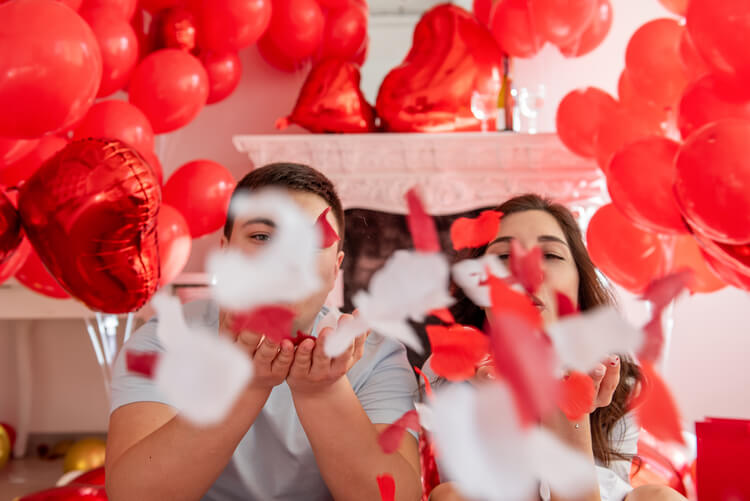 couple blowing rose petals: valentines day